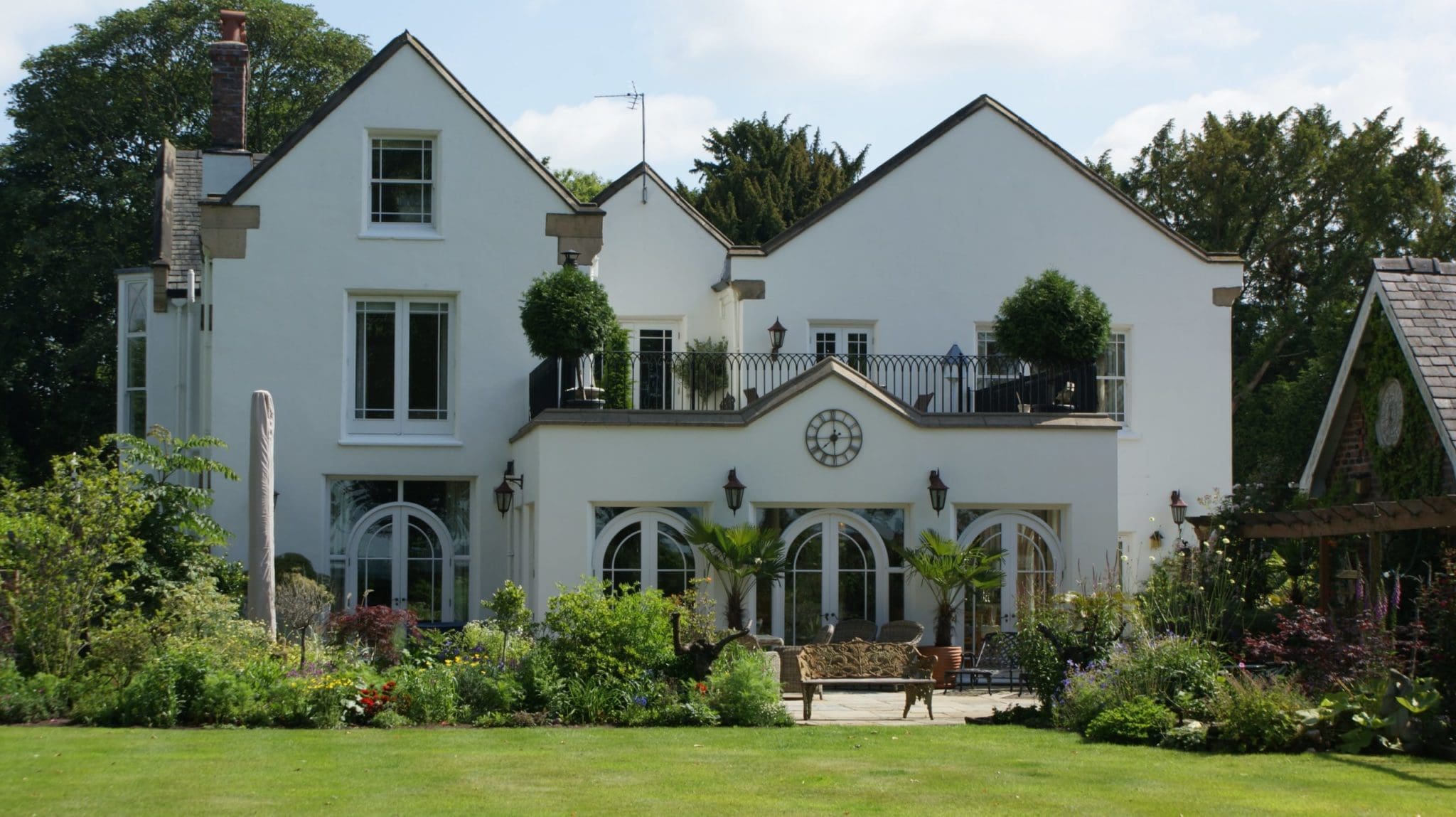 a large white house with a clock on the front of it.