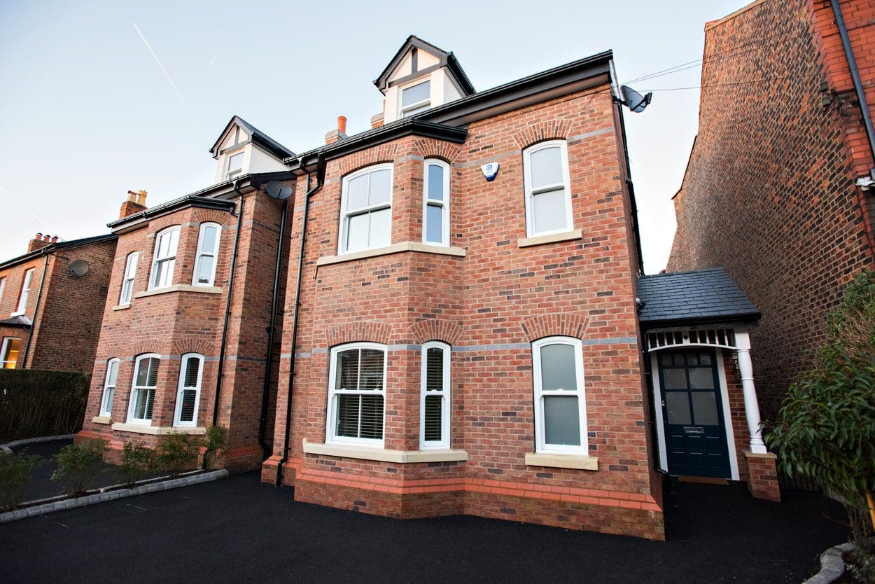 a row of brick houses with white windows.