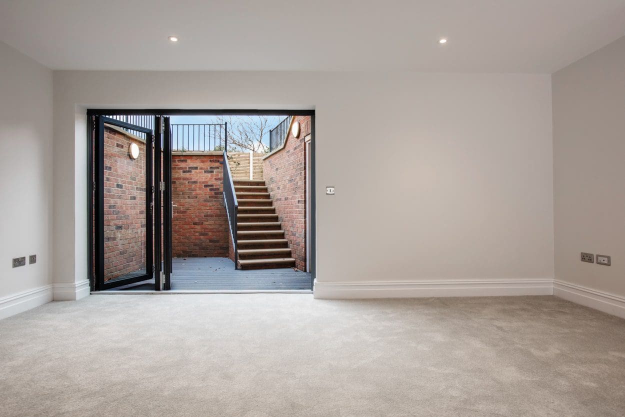 an empty room with a staircase leading to a second floor.