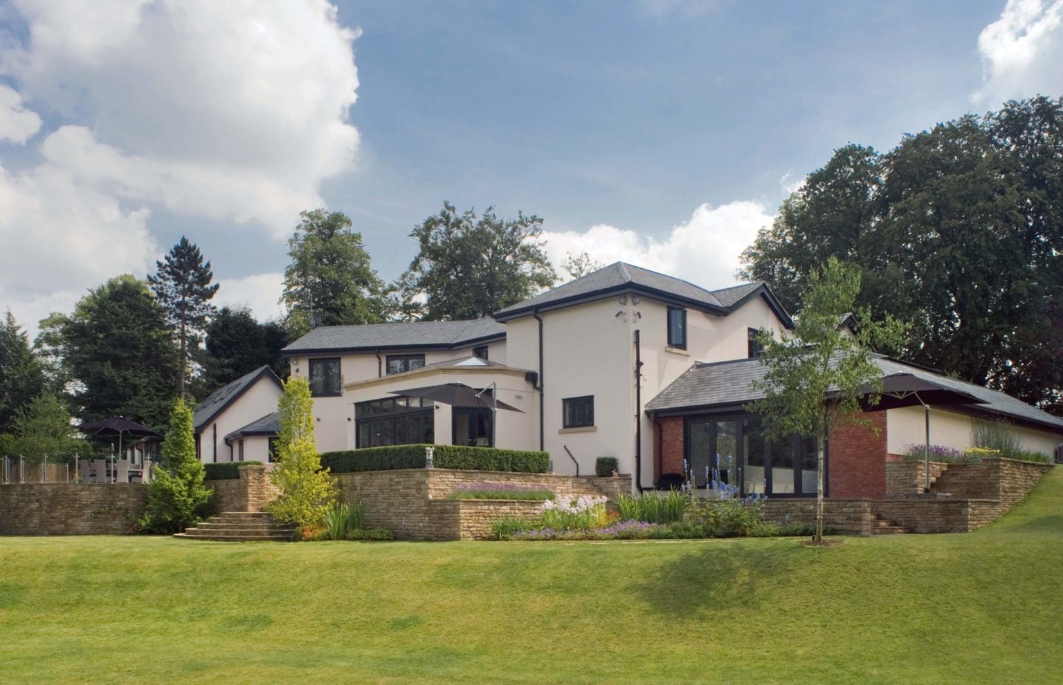 a large white house sitting on top of a lush green field.