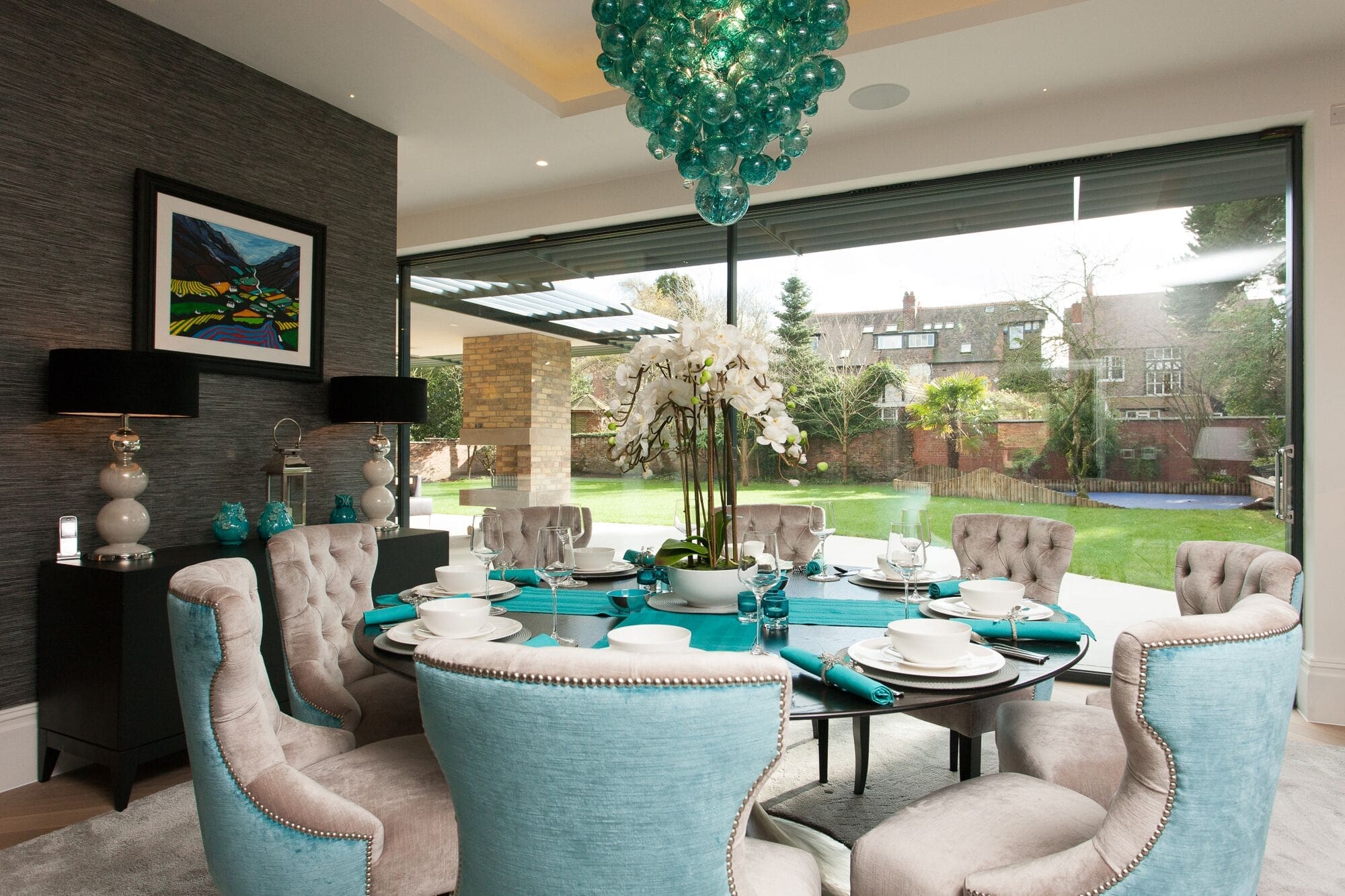 a dining room table with blue chairs and a chandelier.
