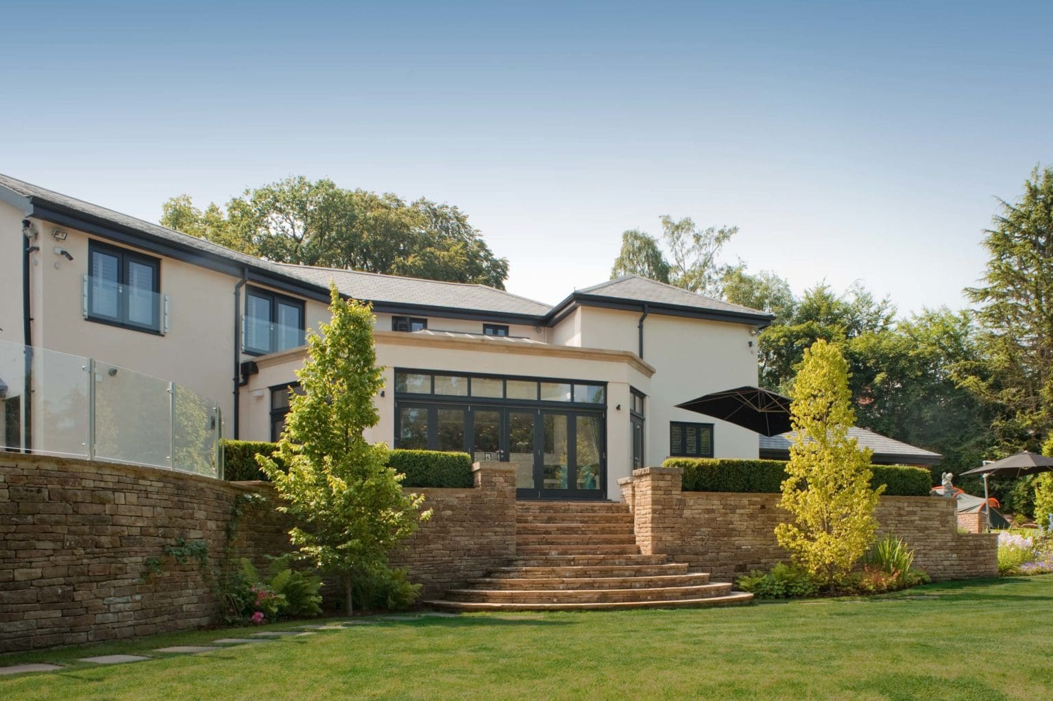 a house with a stone wall and steps leading up to it.