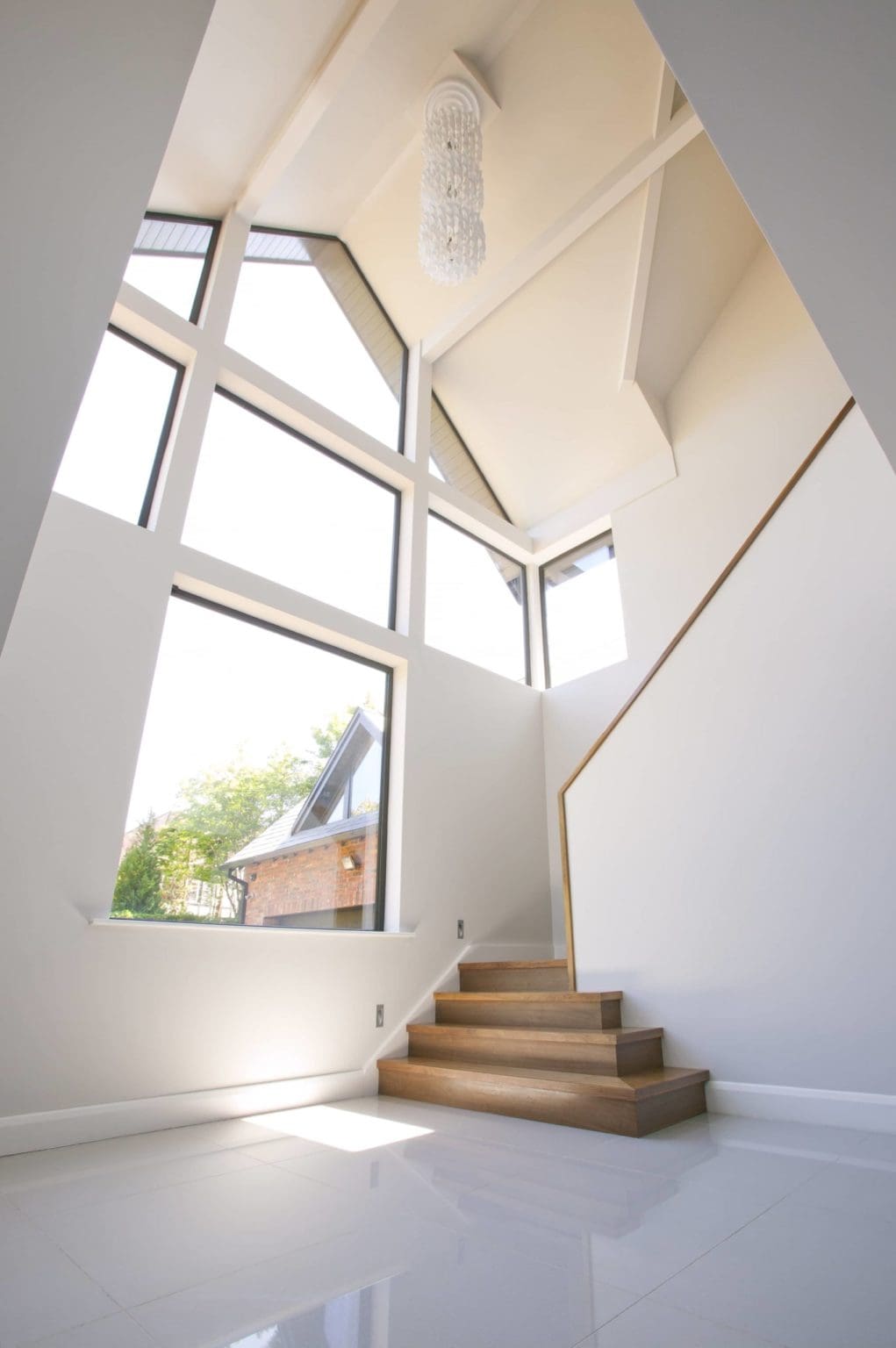 a view of a chandelier in a high ceiling with a lot of windows