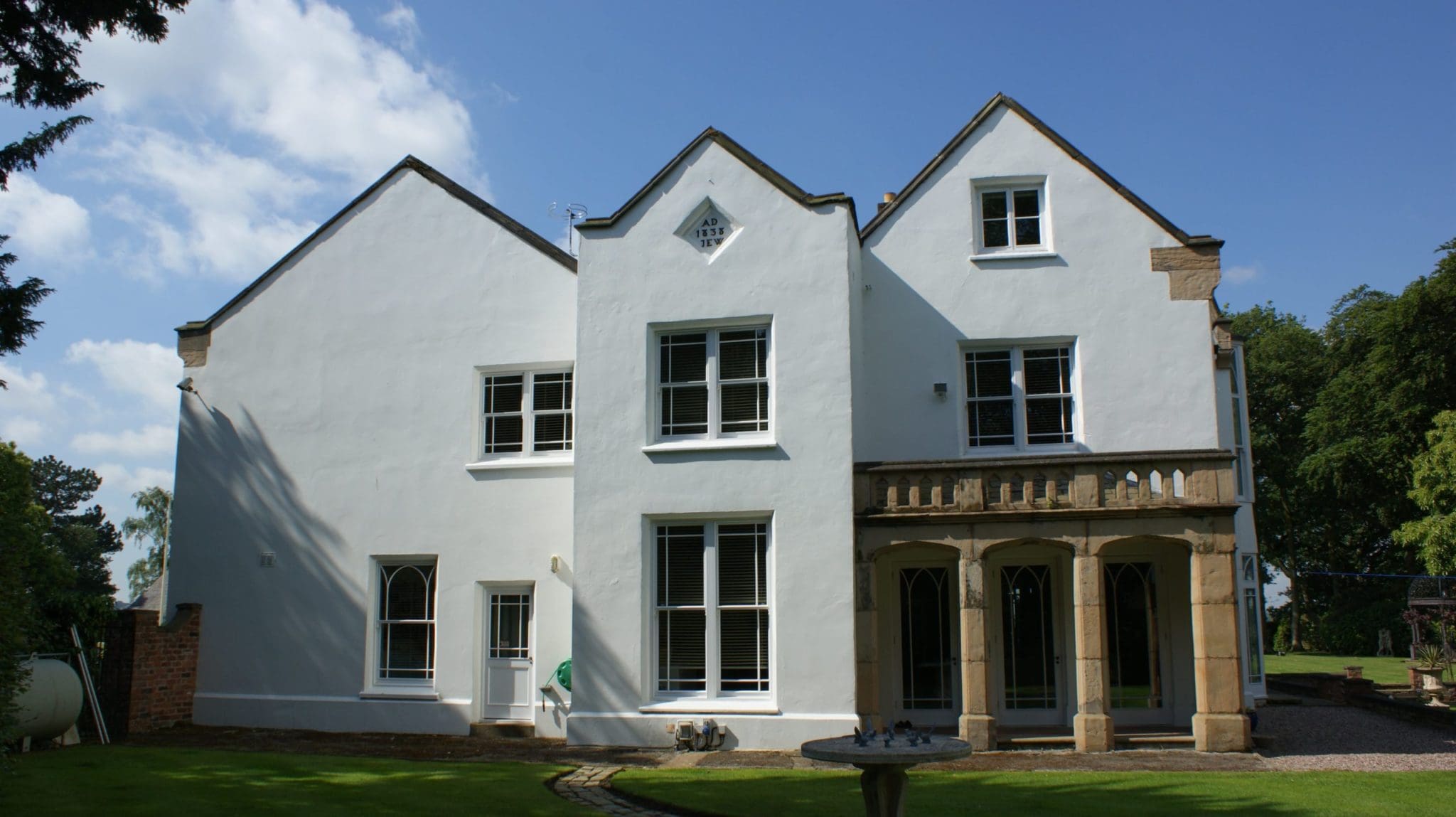 a large white house with a fountain in front of it.