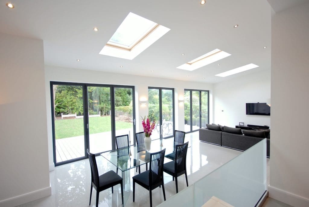 a dining room with a glass table surrounded by black chairs.