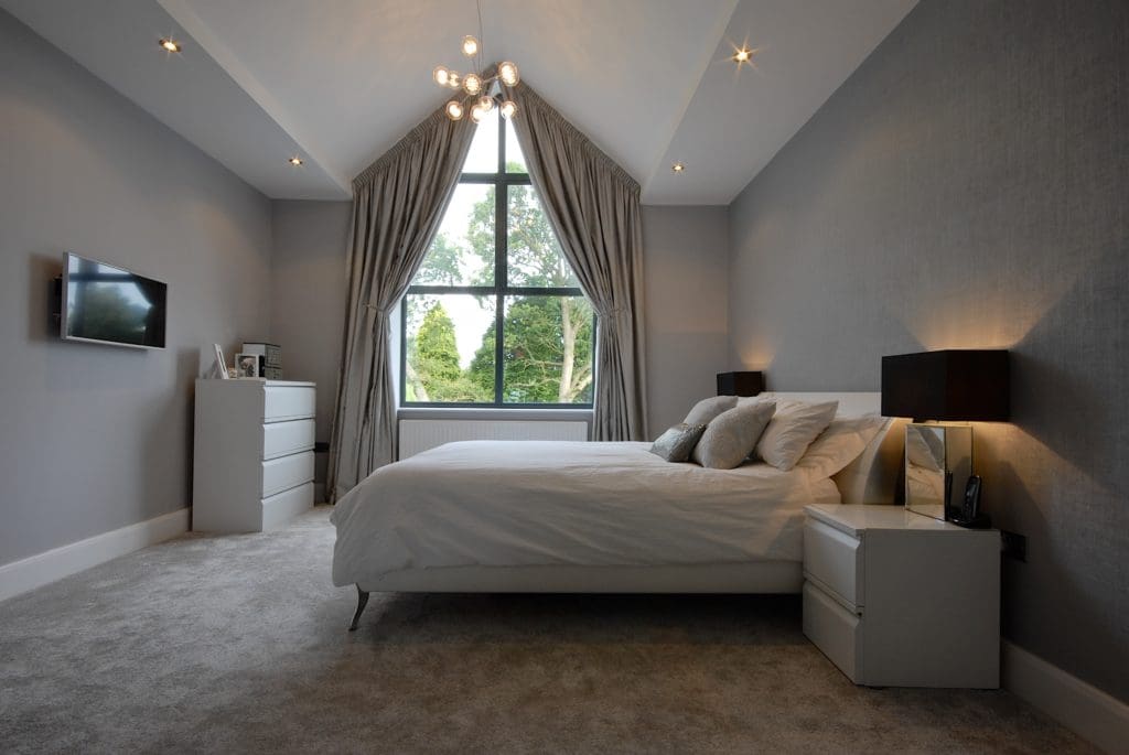 a bedroom with a large bed and a large window.