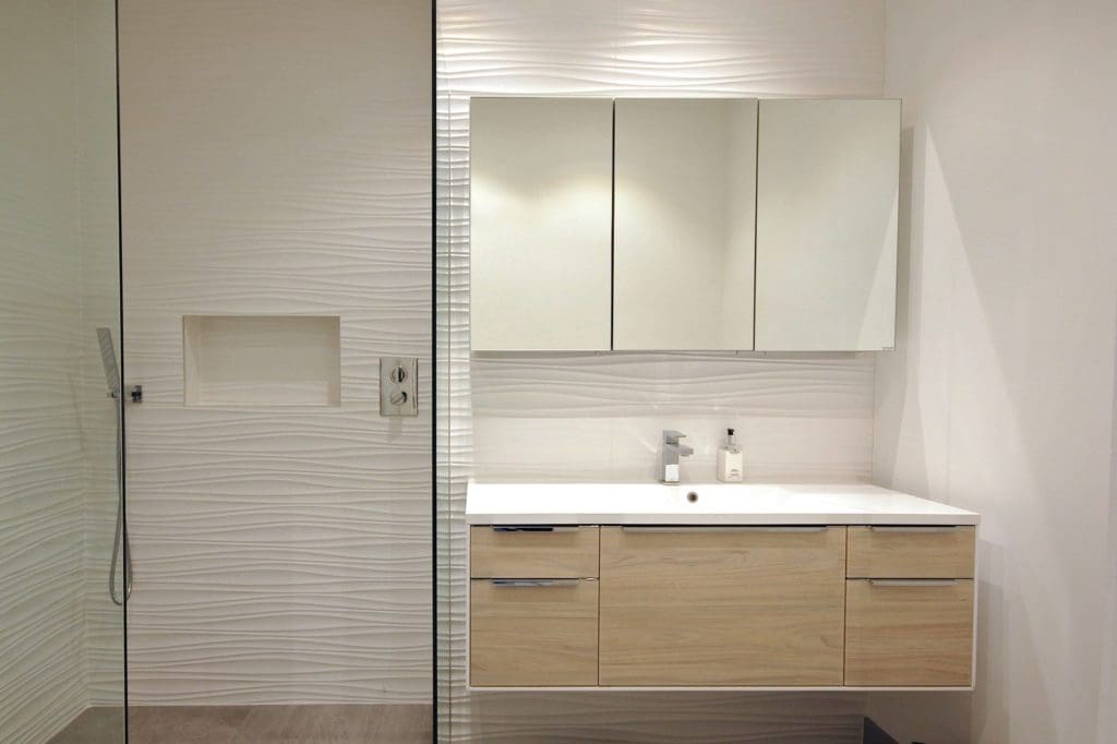a bathroom with a glass shower door and a sink.