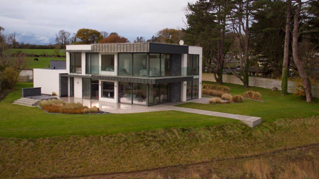 a large house with a lot of windows and grass.