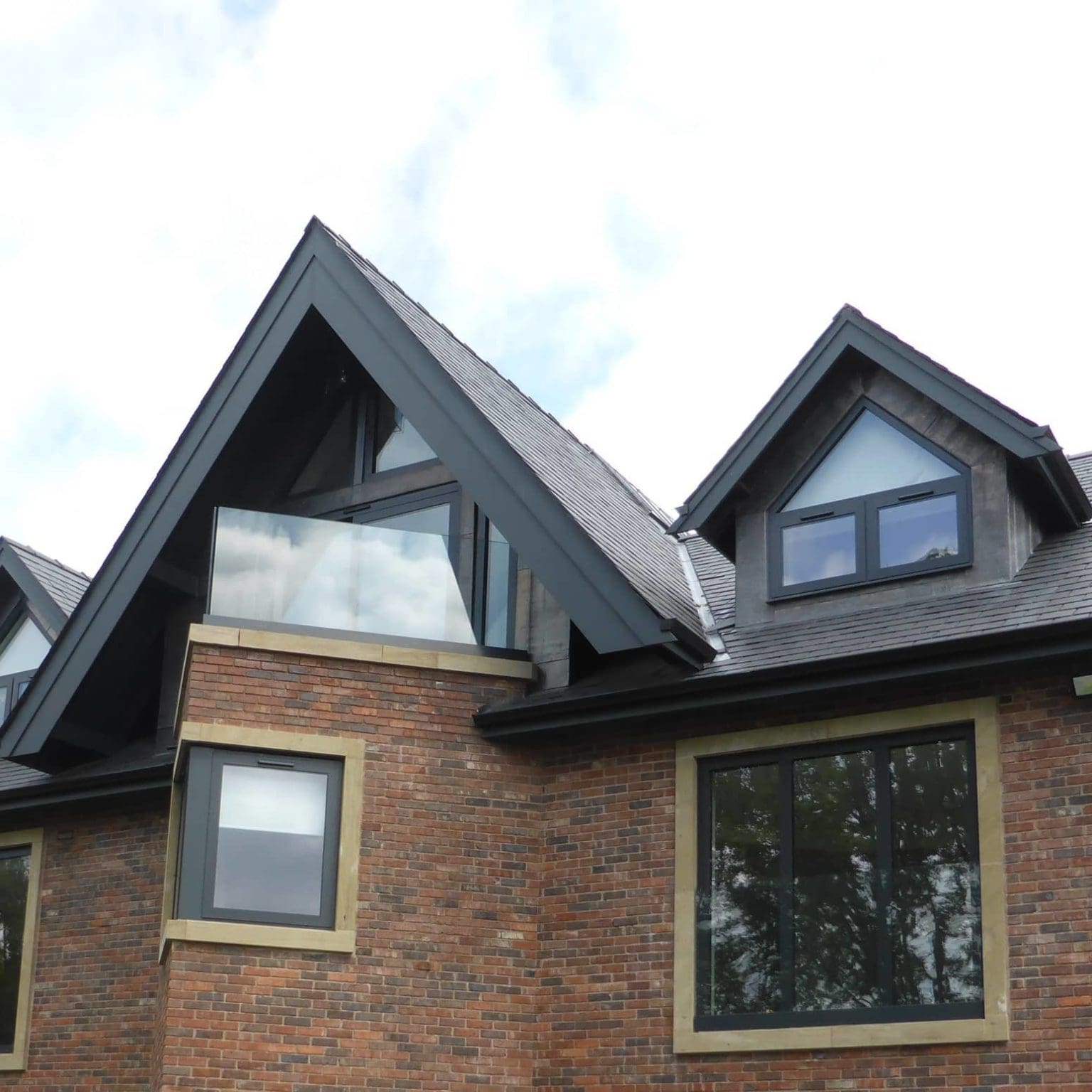 a brick building with three dormers and two windows.