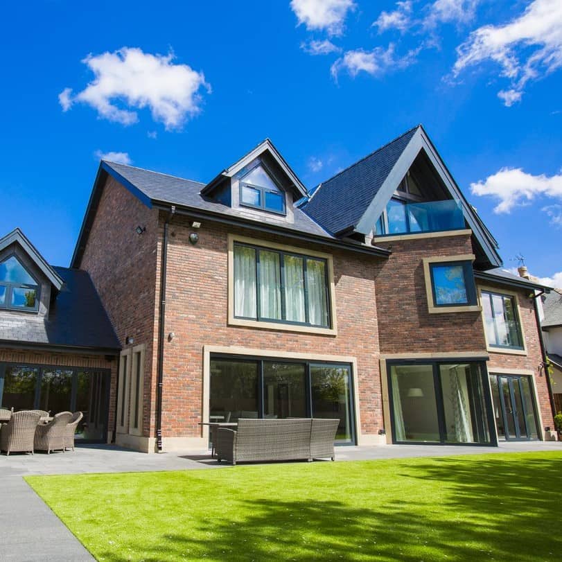 a large brick house with a large lawn.
