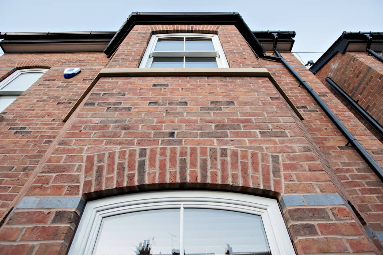 a tall brick building with a white window.