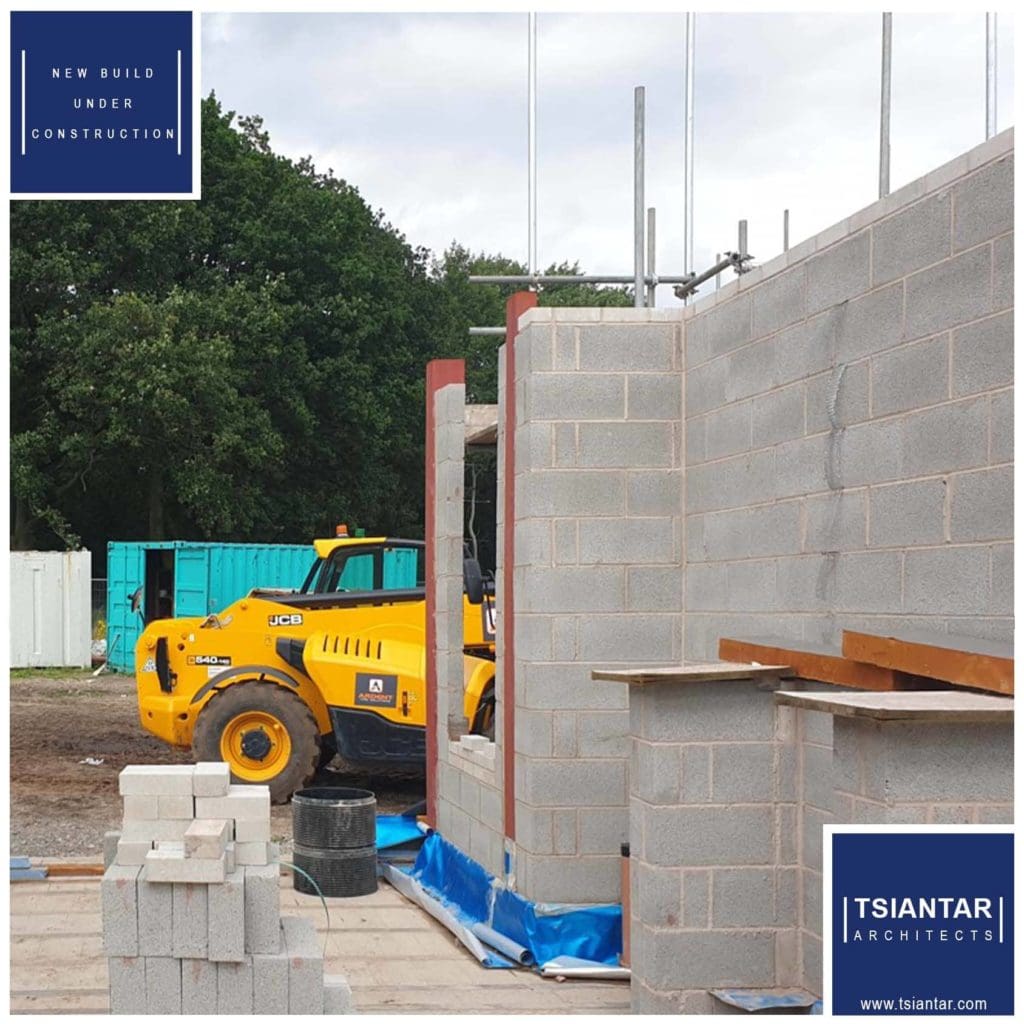 A lakeside property currently under construction showcased by an image of a yellow bulldozer at a construction site.