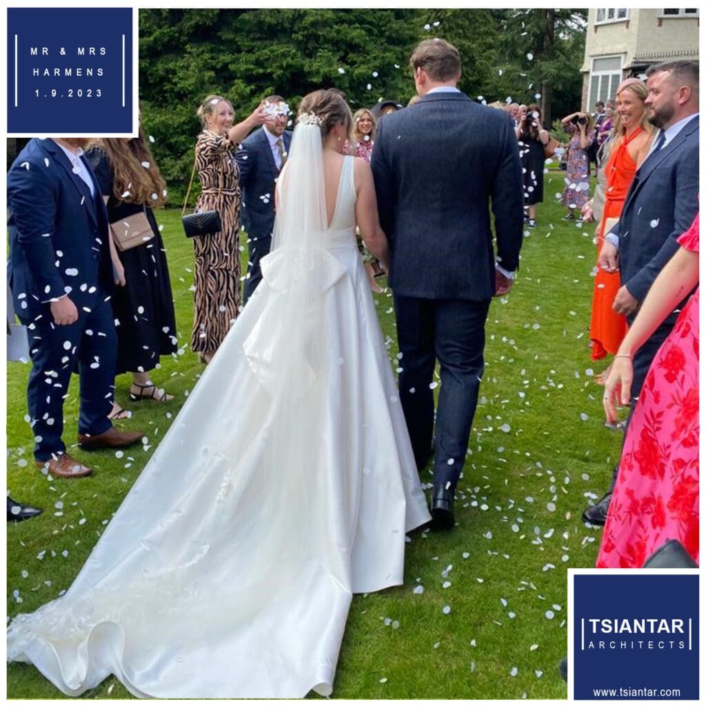 Mr. and Mrs. Harmens being showered with confetti while walking down the aisle.