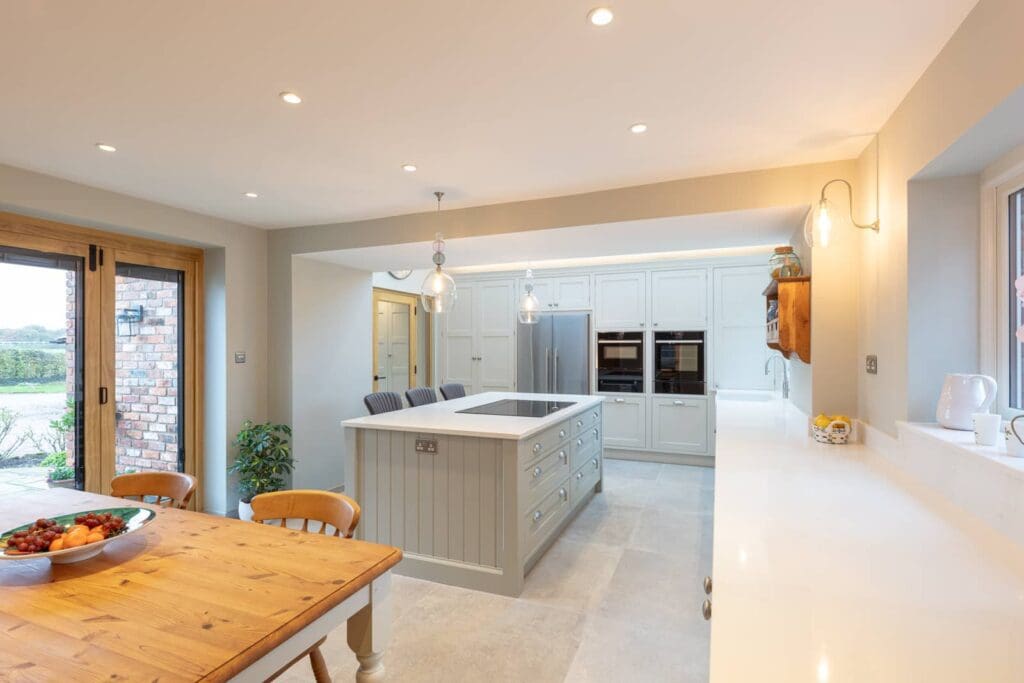 A kitchen with a wooden table and chairs at Sworton Heath Farm.