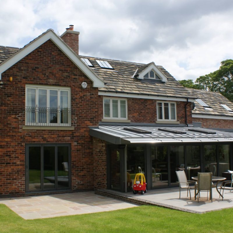 Renovation: A brick house undergoing renovation, with a patio that is being restored.