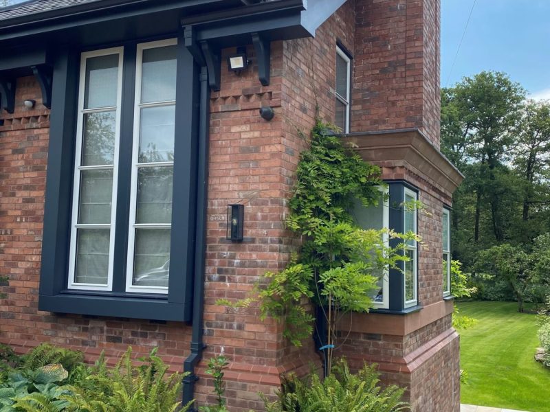 A brick house with a garden in the background.