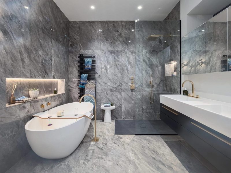 a bathroom with a tub, sink, and mirror.