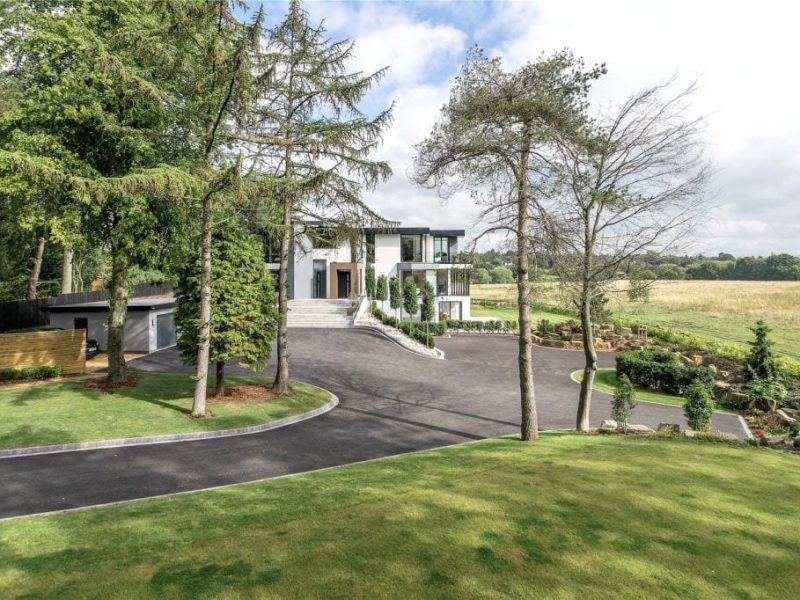 a large white house with a driveway in front of it.