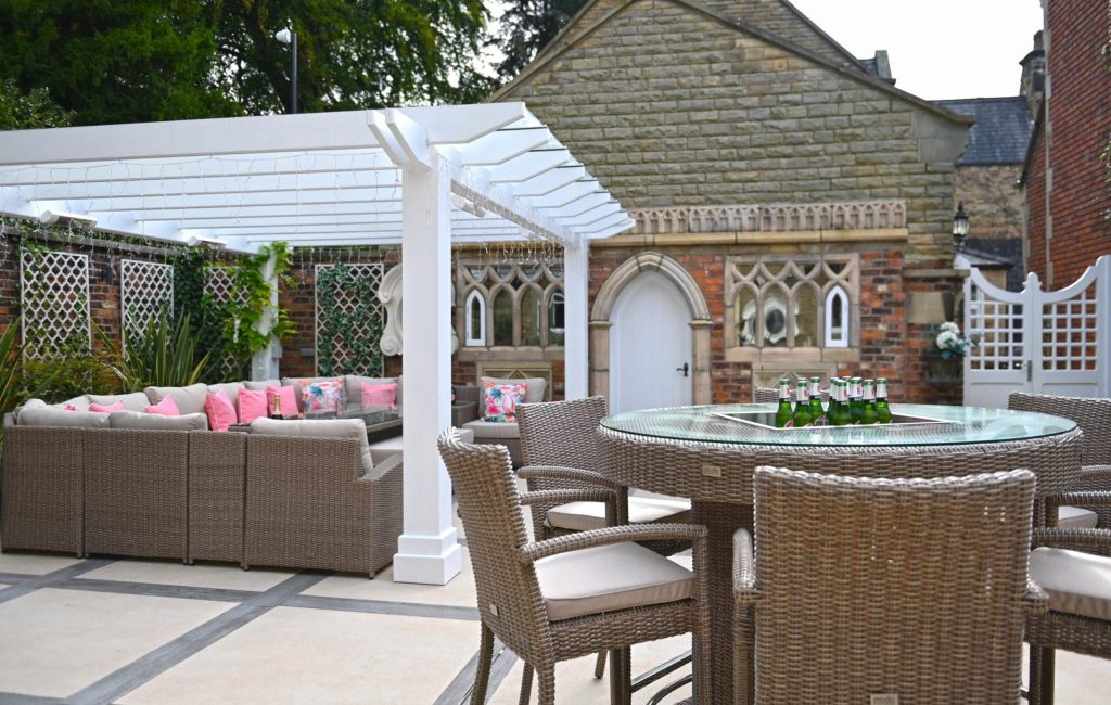 a patio with a table and chairs and a bench.