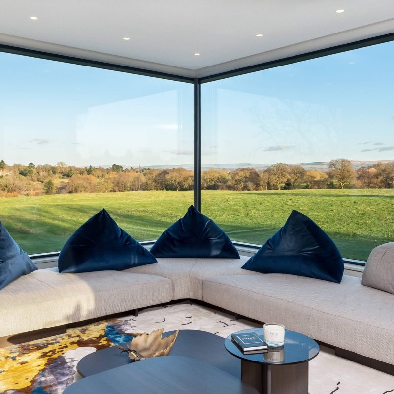 A living room with large windows overlooking a field.